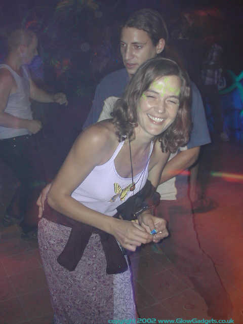 Reveller in frog-themed UV face paint